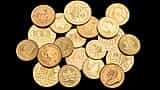 A collection of various gold investment coins resting against a black background.