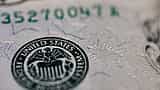 A close-up view of the United States Federal Reserve System seal printed on a dollar bill.