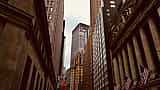 The New York Stock Exchange building stands prominently among skyscrapers on Wall Street.