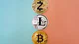 Three cryptocurrency coins, including Zcash and Bitcoin, arranged in a vertical line against a split blue and peach background.