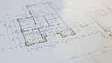 A close-up view of an architectural blueprint and floor plan with highlighted sections.