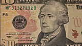 A detailed close-up of a United States ten-dollar bill featuring the portrait of Alexander Hamilton.