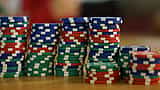 Stacks of colourful poker chips arranged in varying heights on a wooden table.