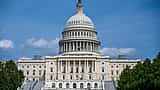 The United States Capitol building stands under a clear blue sky.