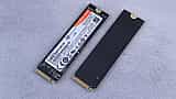Two M.2 NVMe solid-state drives resting side-by-side on a textured gray surface.