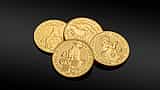Three one-ounce fine gold coins resting on a dark reflective surface.