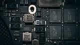 A close-up view of modern microchips and electronic components on a dark computer circuit board.