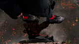 A person wearing Nike sneakers steps into a dark puddle that reflects their silhouette.