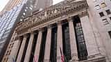 The classic stone facade and columns of the New York Stock Exchange building seen from a low angle.