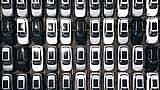 An aerial view shows hundreds of new cars neatly arranged in rows in a massive factory parking lot.