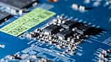 A detailed macro shot of microchips and electronic components on a blue circuit board.