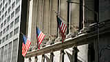 American flags hang between the classical columns of the New York Stock Exchange building.