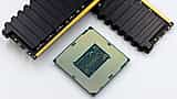A computer processor and several black RAM sticks rest on a white surface.