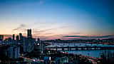 A vibrant view of the Seoul skyline featuring modern skyscrapers and the Han River at twilight.