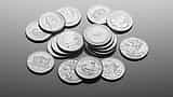 A collection of pristine silver bullion coins resting on a smooth, reflective surface.