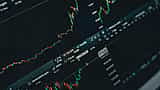 Close-up of a digital stock market trading screen displaying illuminated financial charts and data.