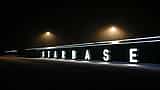 The word Starbase is illuminated in large white letters along a dark wall at night.