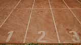 A vibrant red running track with bright white lane markers.