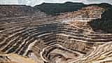 A wide view of a massive, terraced open-pit mine carved deeply into a hillside.