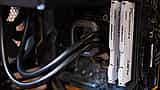 White computer RAM sticks installed alongside a cooling system inside a desktop PC.