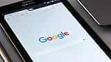 A close-up view of a tablet screen displaying the Google search engine homepage.