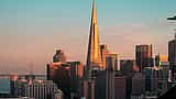 The Transamerica Pyramid and San Francisco skyline catch the warm light of sunset.