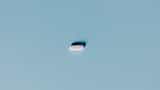 A single white pill centered on a minimalist light blue background.