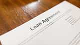A close-up view of a detailed loan agreement document resting on a wooden desk.
