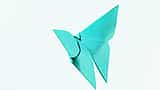 A bright blue origami butterfly folded from paper against a white background.