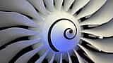 A close-up view of the curved fan blades and central spinner of a modern jet engine.