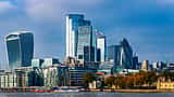 Modern skyscrapers rise along the north bank of the River Thames in London.