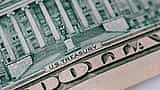 A macro close-up of the back of a U.S. ten-dollar bill showing the U.S. Treasury building and engraving.