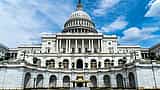 The exterior of the United States Capitol building viewed from the front on a sunny day.