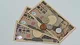 A collection of Japanese yen banknotes and coins arranged on a flat surface.