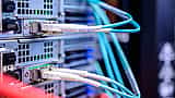 Blue Ethernet cables are connected to the ports of a modern data center server rack.