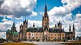 The iconic architecture of Parliament Hill in Ottawa, Canada, standing against a vibrant sky.