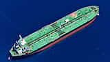 An aerial view of a massive green oil tanker sailing through deep blue ocean waters.