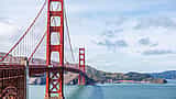 A clear daytime view of the red towers and suspension cables of the Golden Gate Bridge spanning San Francisco Bay.