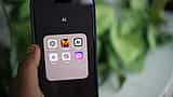 A hand holds a smartphone displaying a folder of artificial intelligence apps, including Anthropic's Claude.