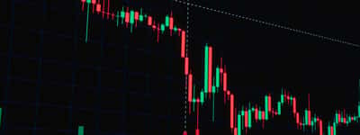 A digital financial chart displaying a sharp downward trend with red candlestick patterns against a dark grid.