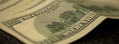 A moody macro close-up of a US one hundred dollar bill.