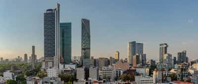 The modern skyline of Mexico City's financial district rises against a clear sky.