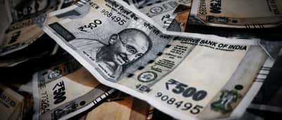 A scattered pile of Indian 500-rupee banknotes featuring the portrait of Mahatma Gandhi.