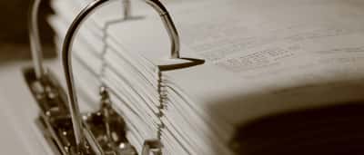 A close-up view of a thick binder filled with dense paperwork and documents.