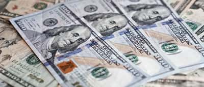 A detailed close-up of a scattered arrangement of United States dollar banknotes.