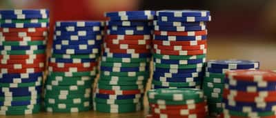Stacks of colourful poker chips arranged in varying heights on a wooden table.