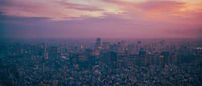 An aerial view of the Tokyo skyline at twilight with glowing city lights.