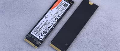 Two M.2 NVMe solid-state drives resting side-by-side on a textured gray surface.