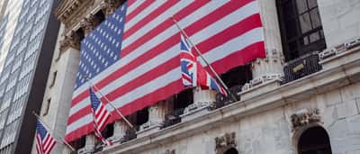 An American flag hangs from the ornate stone facade of a historic building.