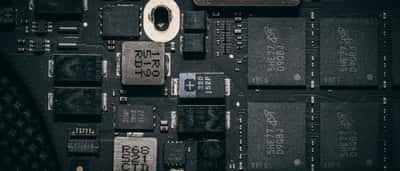 A close-up view of modern microchips and electronic components on a dark computer circuit board.